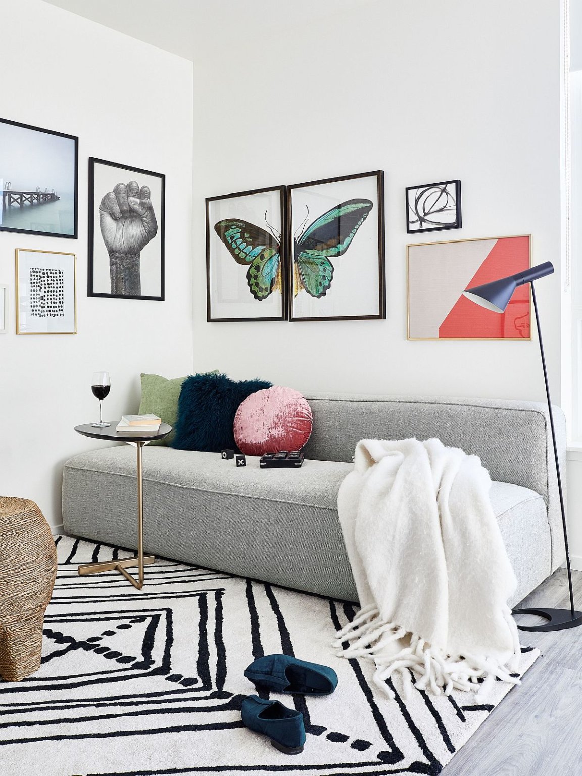 h&igrave;nh ảnh ph&ograve;ng kh&aacute;ch với sofa ghi x&aacute;m, bộ tranh treo tường họa tiết bướm, thảm trải họa tiết đen trắng