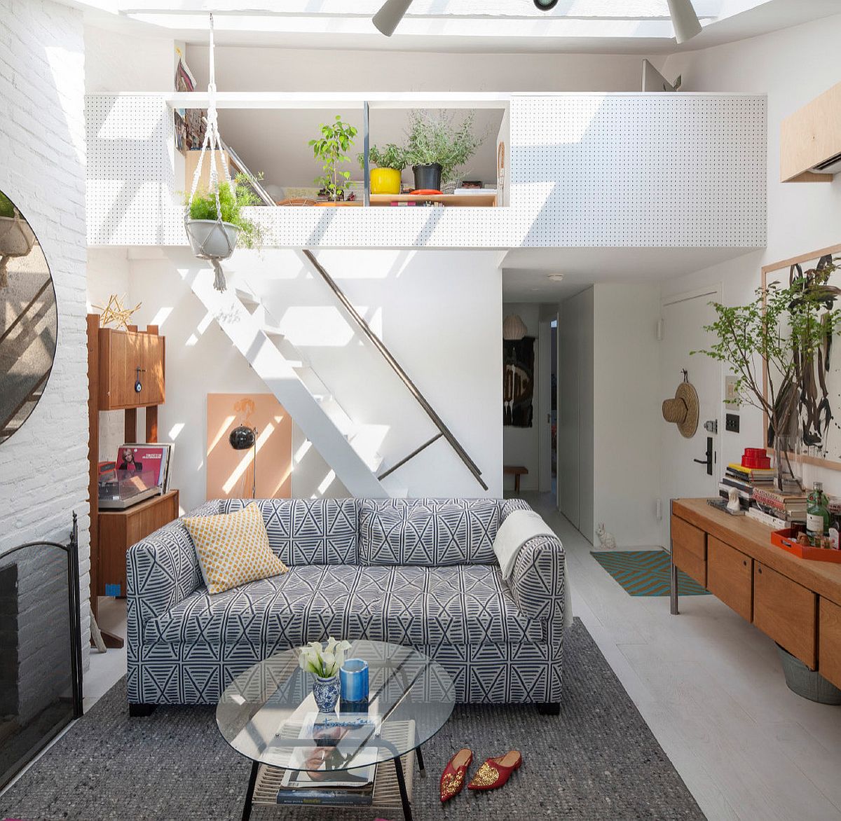 h&igrave;nh ảnh ph&ograve;ng kh&aacute;ch nhỏ thanh lịch với sofa bọc vải họa tiết, b&agrave;n tr&agrave; k&iacute;nh tr&ograve;n đặt tr&ecirc;n thảm trải m&agrave;u ghi