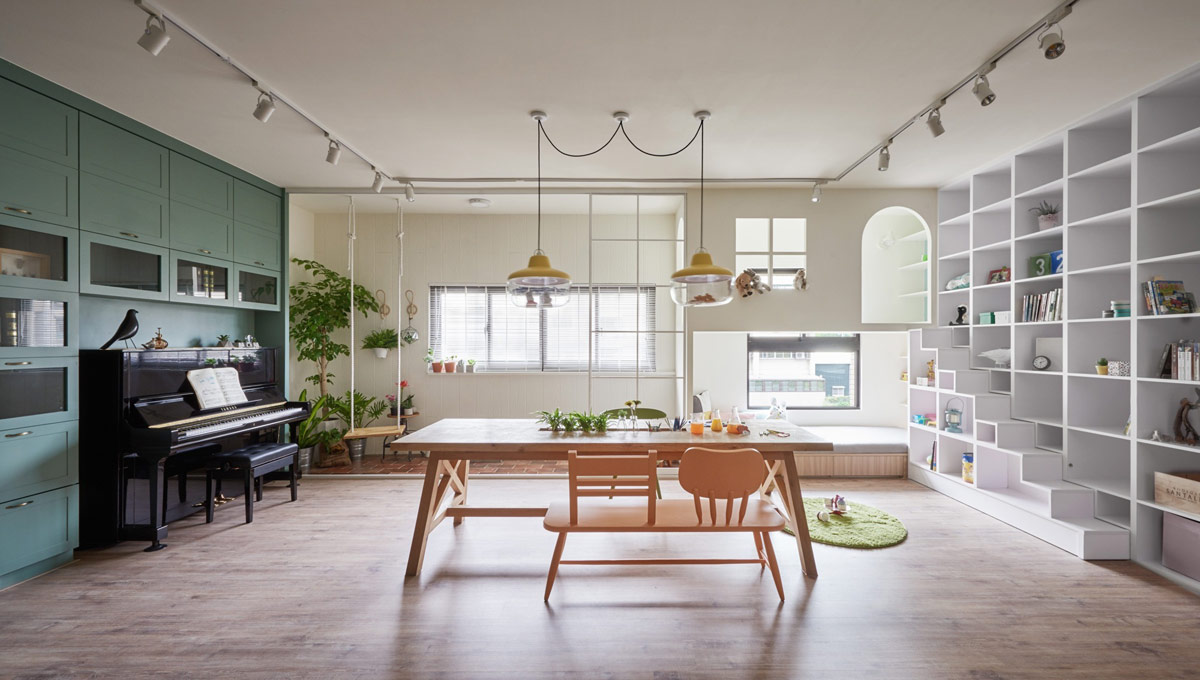 h&igrave;nh ảnh kh&ocirc;ng gian b&ecirc;n trong ng&ocirc;i nh&agrave; 138m2 ở Đ&agrave;i Loan với b&agrave;n gỗ trung t&acirc;m, đ&agrave;n piano ở g&oacute;c, cửa sổ k&iacute;nh tho&aacute;ng s&aacute;ng, tủ &acirc;m tường m&agrave;u xanh l&aacute;