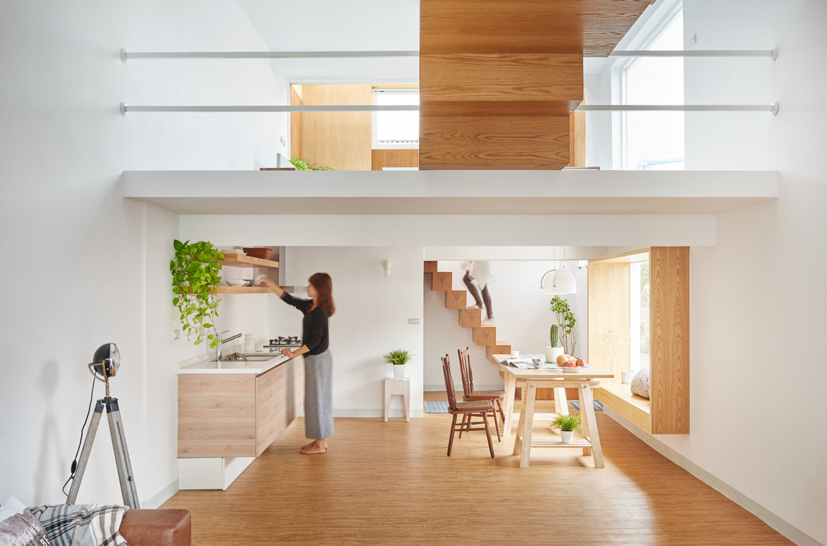 h&igrave;nh ảnh c&ocirc; g&aacute;i trẻ đang đứng trong ph&ograve;ng bếp kết hợp ph&ograve;ng ăn c&oacute; khung cửa sổ k&iacute;nh lớn ngập tr&agrave;n &aacute;nh s&aacute;ng
