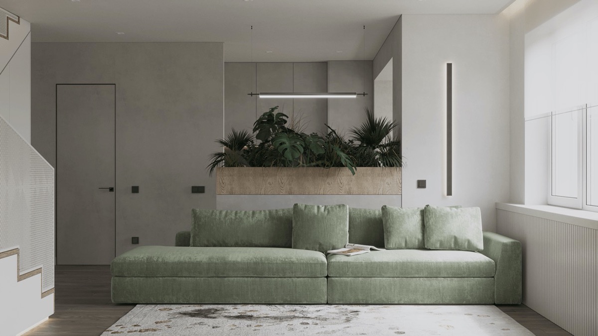 h&igrave;nh ảnh ph&ograve;ng kh&aacute;ch căn hộ 74m2 với ghế sofa d&agrave;i m&agrave;u xanh l&aacute; nhẹ nh&agrave;ng, ph&iacute;a sau l&agrave; bồn gỗ trồng c&acirc;y xanh