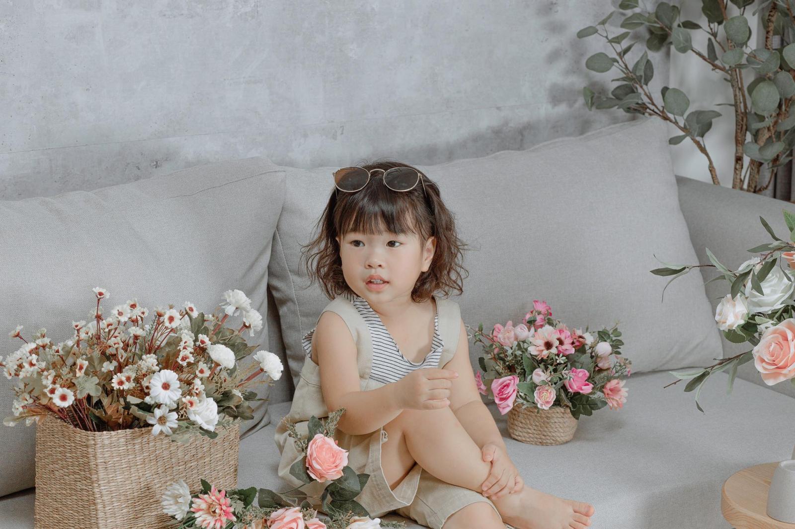 B&eacute; g&aacute;i ngồi tr&ecirc;n sofa
