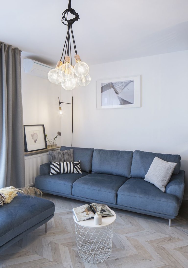 h&igrave;nh ảnh ph&ograve;ng kh&aacute;ch nhỏ xinh với gối sofa xanh, gối tựa kẻ sọc, đ&egrave;n ch&ugrave;m, b&agrave;n tr&agrave; m&agrave;u trắng tr&ograve;n