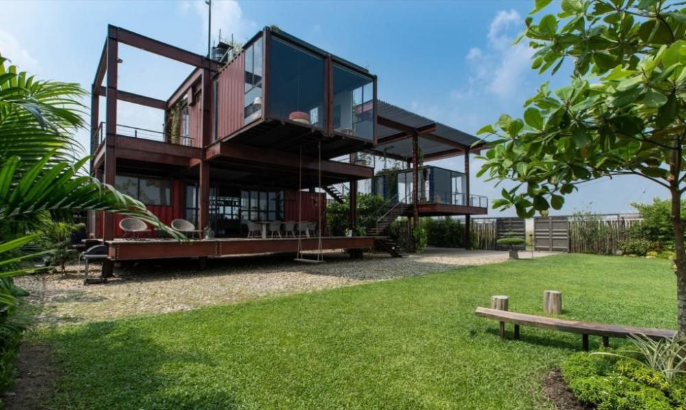 hình ảnh ngôi nhà container ở Dhaka (Bangladesh) tông màu nâu trầm, cửa kính trong suốt, xung quanh có nhiều cây cối