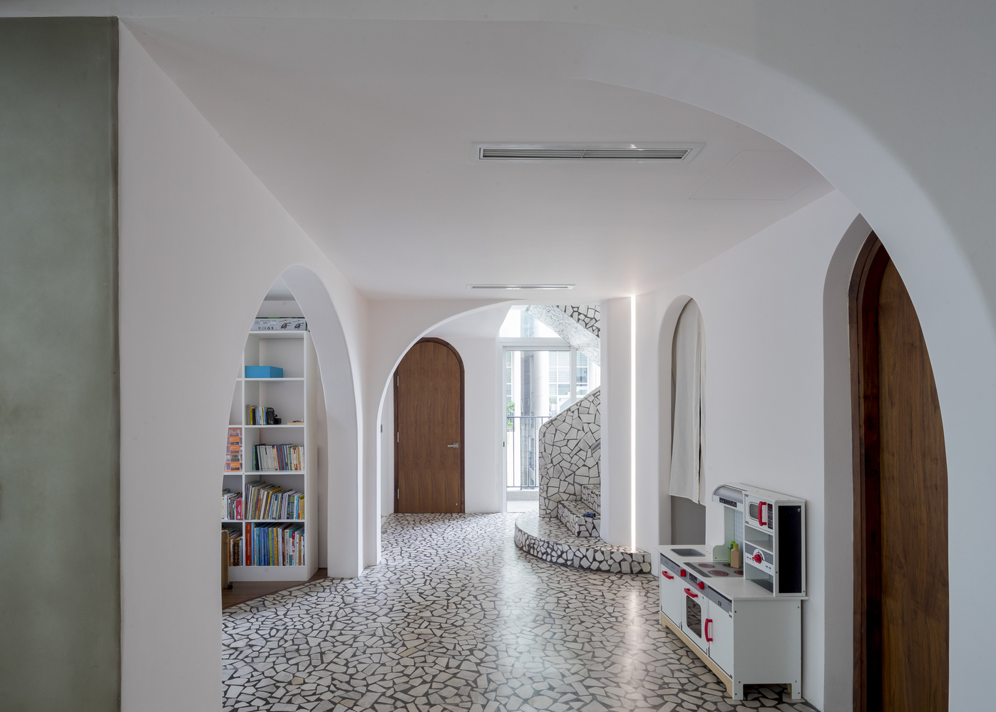 hình ảnh không gian thoáng sáng bên trong căn hộ duplex ở Sài Gòn với sàn lát gạch terrazzo, các khung cửa hình vòm mềm mại