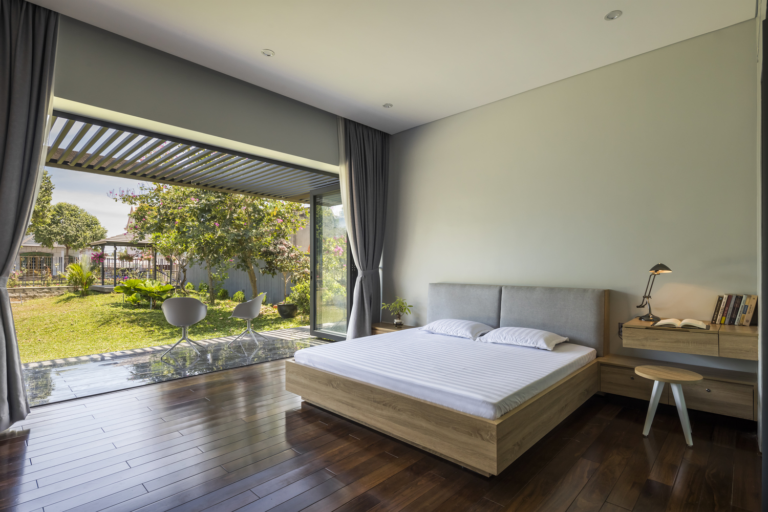 h&igrave;nh ảnh ph&ograve;ng ngủ tho&aacute;ng rộng với cửa lớn mở hướng ra s&acirc;n vườn xanh m&aacute;t
