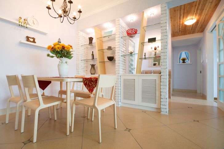 h&igrave;nh ảnh một ph&ograve;ng ăn hiện đại t&ocirc;ng m&agrave;u trắng s&aacute;ng chủ đạo, đ&egrave;n ch&ugrave;m trang tr&iacute;, b&igrave;nh hoa hướng dương đặt tr&ecirc;n b&agrave;n