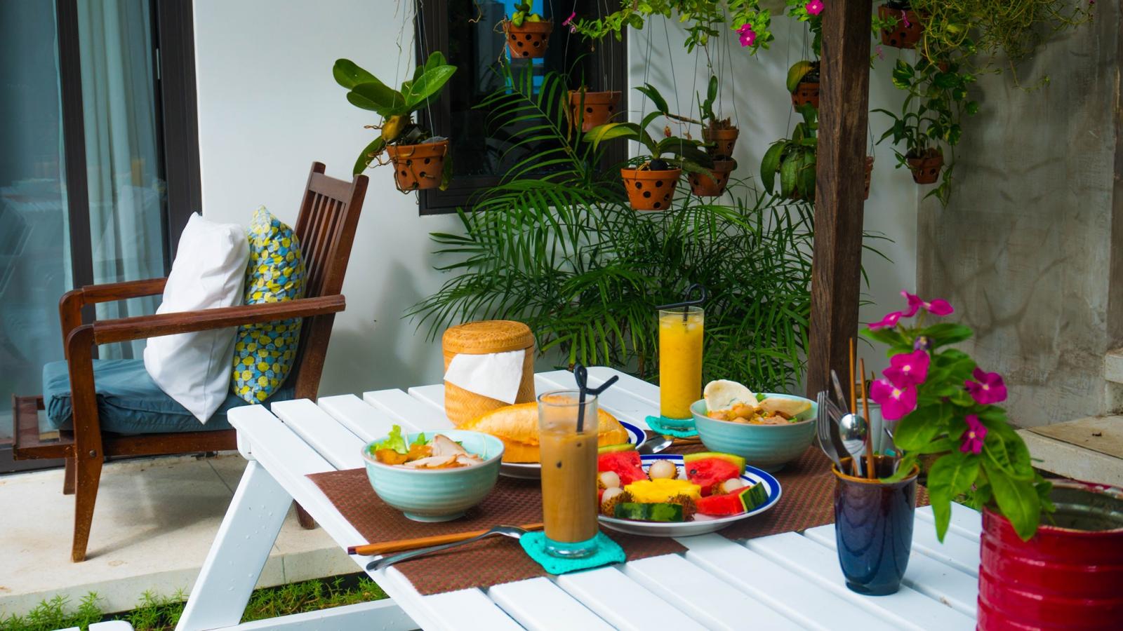 àn ăn ở mảng sân vườn trước nhà là "góc ăn nhậu" ưa thích của gia chủ và người thân, bạn bè. Bàn ăn ngoài trời