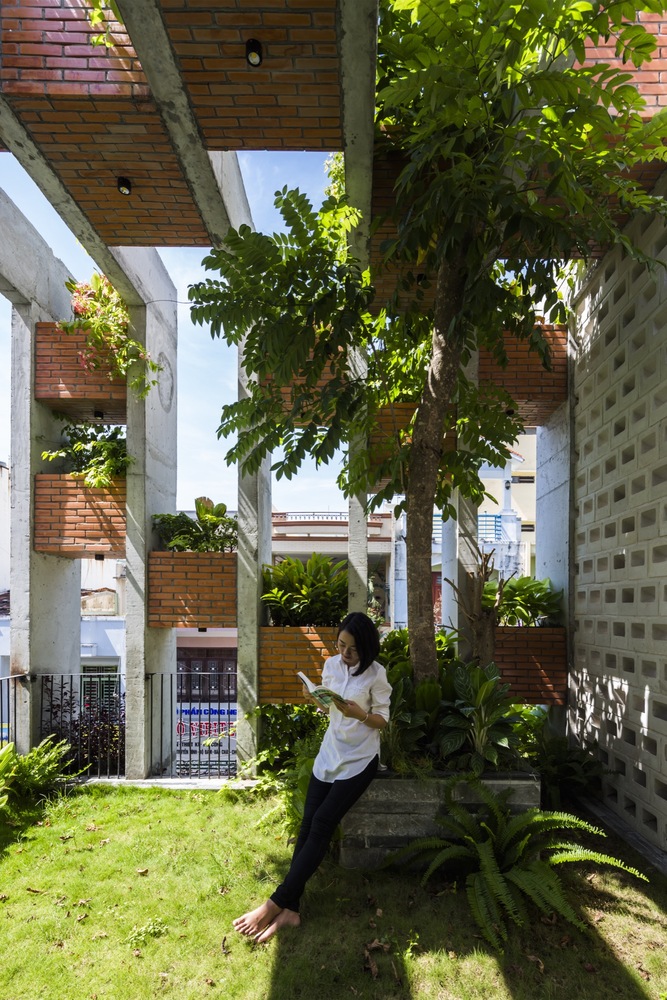 hình ảnh cô gái trẻ đứng đọc sách dưới tán cây xanh