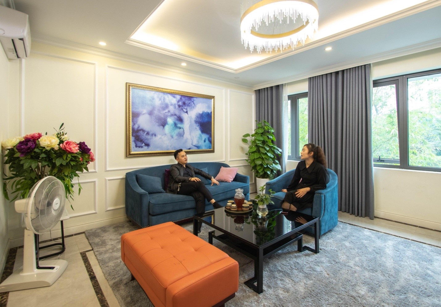 h&igrave;nh ảnh hai người đang ngồi tr&ograve; chuyện trong ph&ograve;ng kh&aacute;ch căn shophouse sang trọng, tinh tế