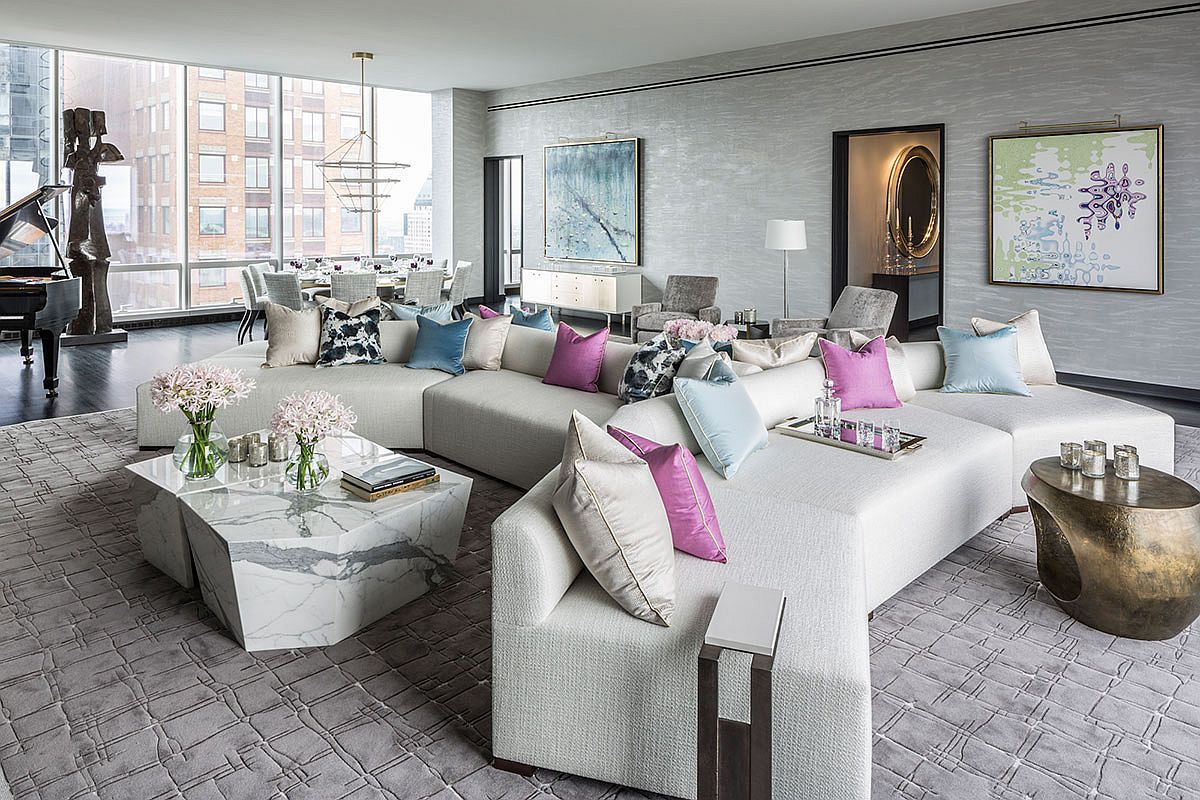 h&igrave;nh ảnh ph&ograve;ng kh&aacute;ch căn hộ sang trọng ở Manhattan nổi bật với bộ ghế sofa t&ocirc;ng m&agrave;u trung t&iacute;nh, điểm xuyết gối tựa m&agrave;u t&iacute;m oải hương, xanh dương nhạt.