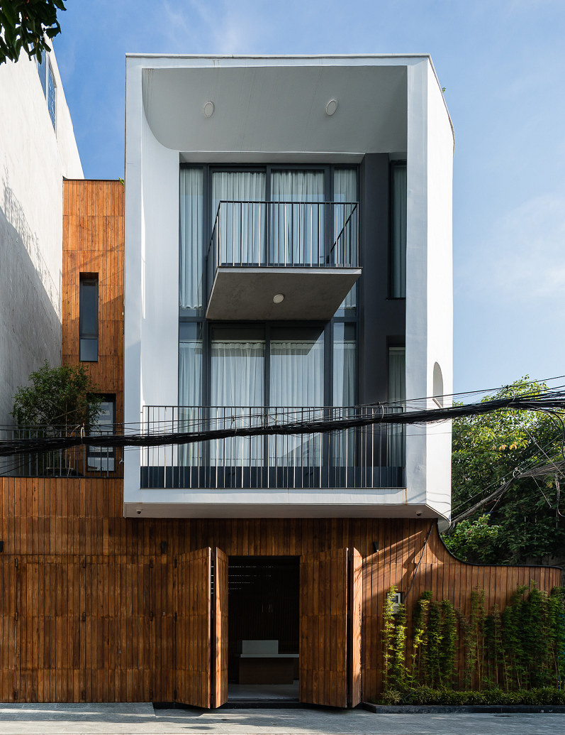 Mặt tiền nh&agrave; phố ấn tượng với hệ tường r&agrave;o v&agrave; cửa gỗ như h&ograve;a l&agrave;m một.