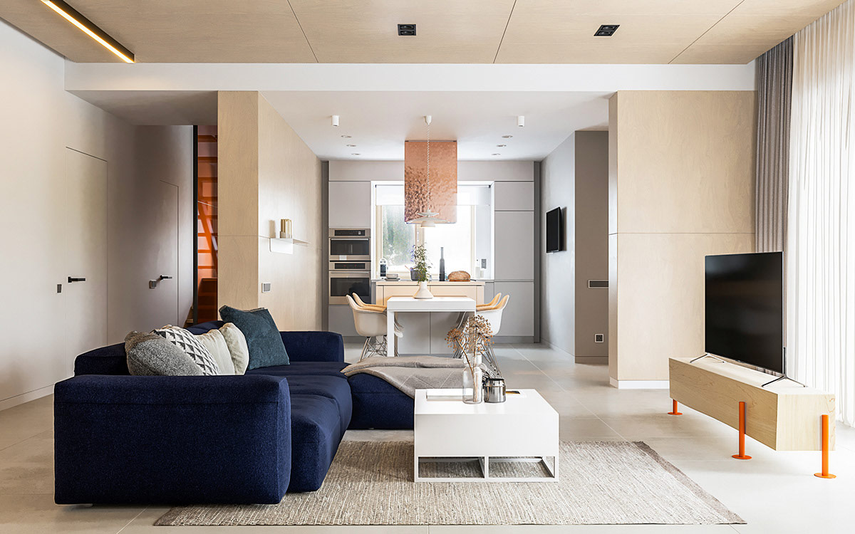 B&agrave;n tr&agrave; m&agrave;u trắng tinh nổi bật đặt tr&ecirc;n thảm trải m&agrave;u x&aacute;m nh&atilde; nhặn. Bộ ghế sofa m&agrave;u xanh dương gi&uacute;p kh&ocirc;ng gian tiếp kh&aacute;ch như c&oacute; chiều s&acirc;u hơn.