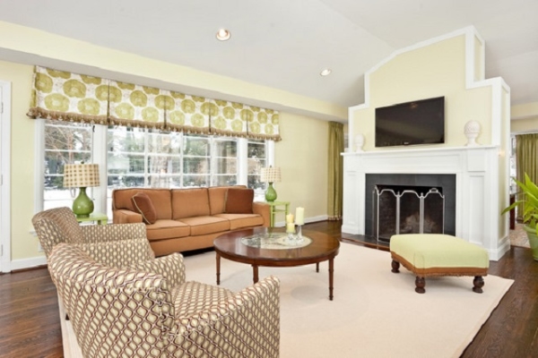 Ghế sofa dài, hai ghế bành và ghế phụ được đặt xoay xung quanh bàn trà và đối xứng qua món nội thất trung tâm này.