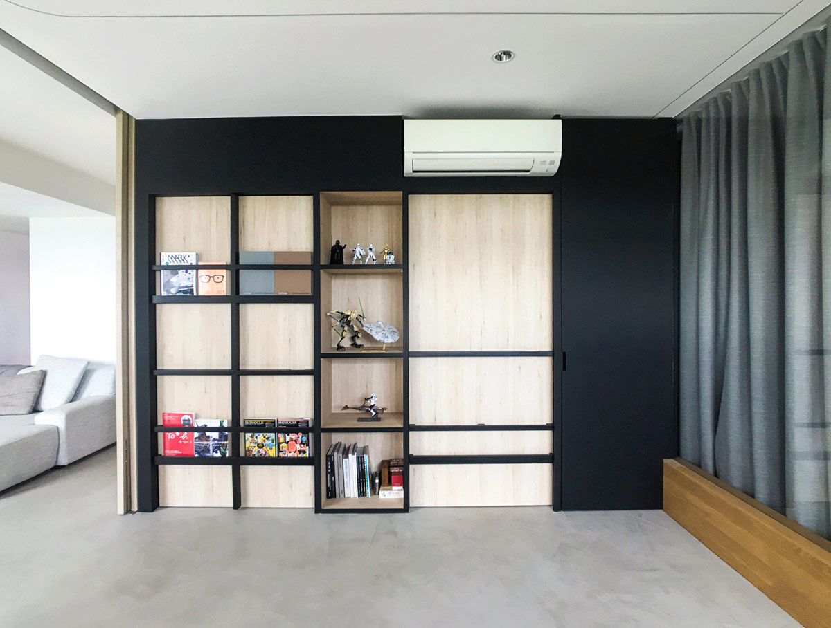 Gi&aacute; s&aacute;ch dọc theo bức tường, tạo điểm nhấn h&uacute;t mắt bởi gam mau tương phản với tổng thể kh&ocirc;ng gian sinh hoạt chung.
