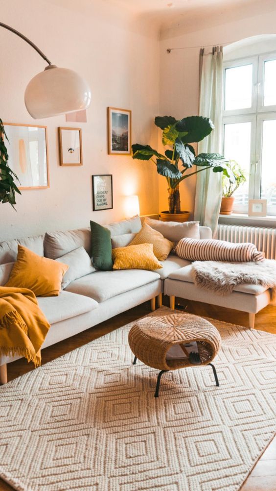 ph&ograve;ng kh&aacute;ch nhỏ với sofa m&agrave;u sữa, gối tựa v&agrave;ng, đ&egrave;n s&agrave;n m&agrave;u trắng
