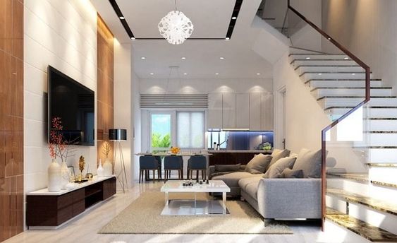 Ph&ograve;ng kh&aacute;ch được thiết kế v&agrave; b&agrave;i tr&iacute; đơn giản, gọn đẹp với bộ sofa m&agrave;u ghi x&aacute;m, b&agrave;n tr&agrave; c&ugrave;ng t&ocirc;ng với kệ tivi đối diện.