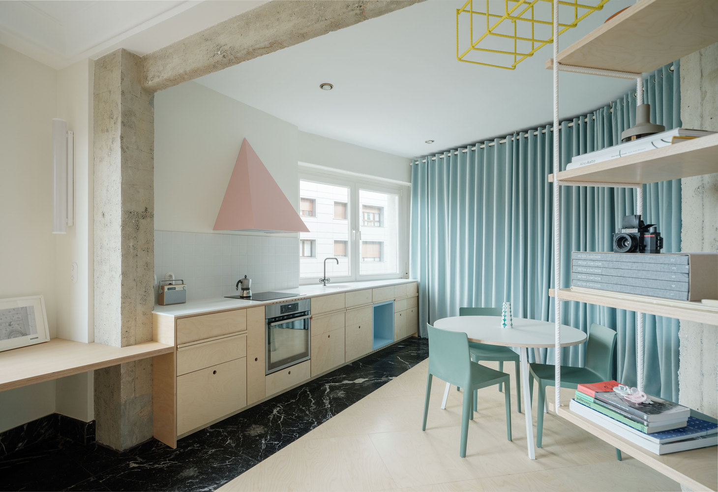 ph&ograve;ng bếp tho&aacute;ng s&aacute;ng, b&agrave;n học tr&ograve;n đặt cạnh gi&aacute; kệ m&agrave;u trắng