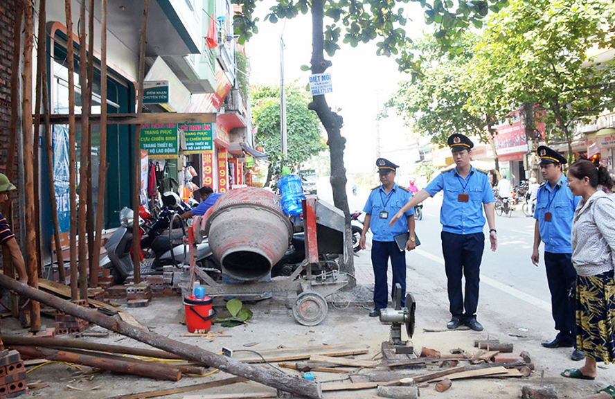 3 người đ&agrave;n &ocirc;ng v&agrave; một phụ nữ đang đứng trước một ng&ocirc;i nh&agrave; đang thi c&ocirc;ng x&acirc;y dựng