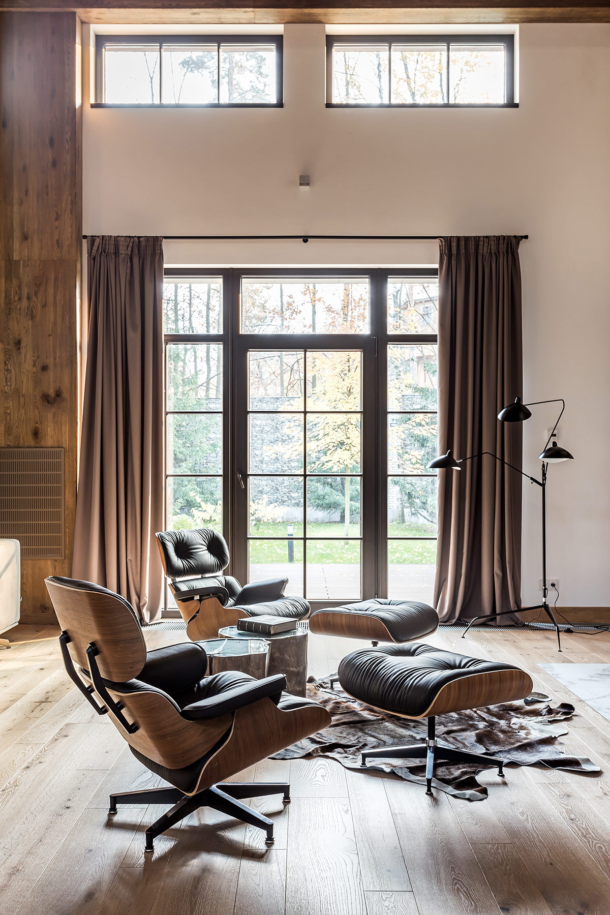 Hai chiếc ghế salon kiểu Eames v&agrave; ghế đ&ocirc;n ph&ugrave; hợp để c&aacute;c th&agrave;nh vi&ecirc;n gia đ&igrave;nh qu&acirc;y quần b&ecirc;n l&ograve; sưởi ấm &aacute;p.
