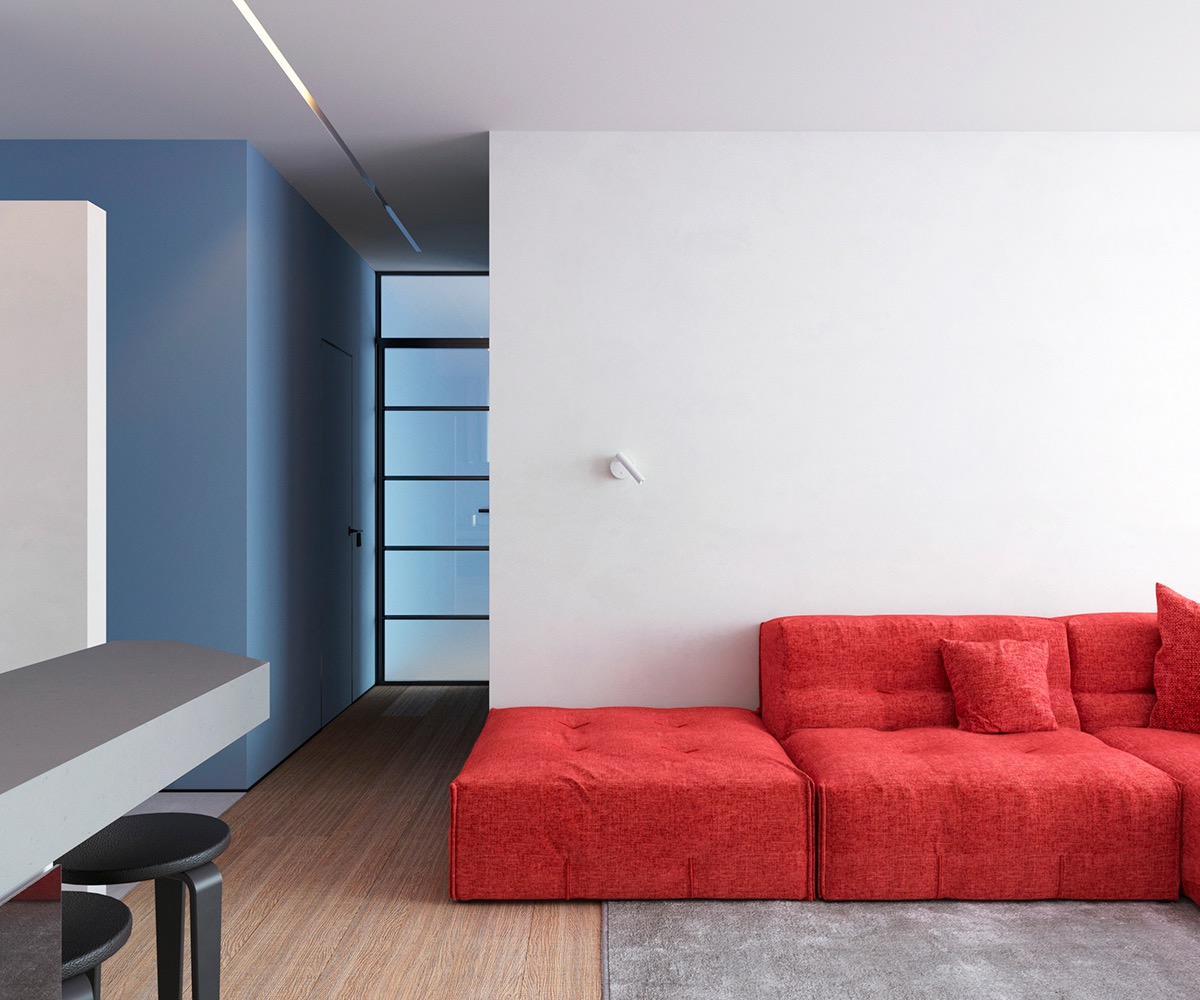 Trong ph&ograve;ng kh&aacute;ch căn hộ 64m2, ghế sofa m&agrave;u đỏ chiếm ưu thế trong khu vực chung, mọi thứ kh&aacute;c được loại bỏ ngoại trừ chiếc đ&egrave;n treo tường hiện đại m&agrave;u trắng.
