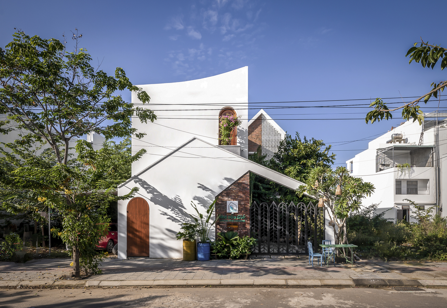 Nhà của gió gây ấn tượng bởi thiết kế mặt tiền đơn giản, hiện đại và rất bắt mắt với sắc trắng chủ đạo làm nền cho sắc xanh thiên nhiên và màu nâu gỗ, nâu đất nổi bật hơn.