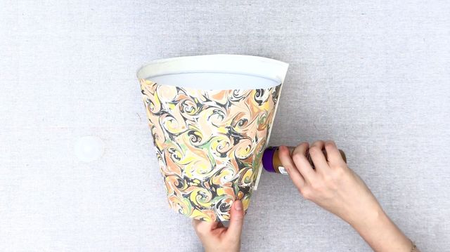 Dùng keo để cố định mép giấy trang trí.