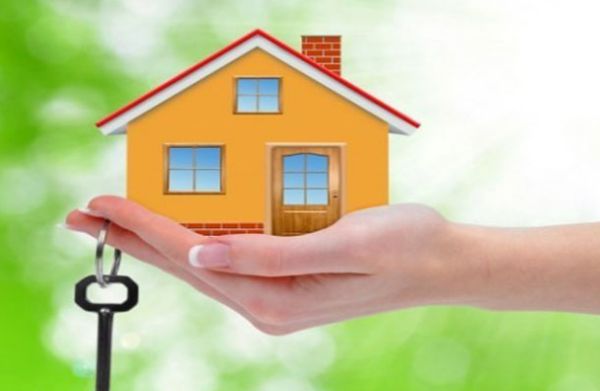 hình ảnh bàn tay nâng mô hình ngôi nhà màu vàng, cửa sổ kính, ngói đỏ, chìa khóa