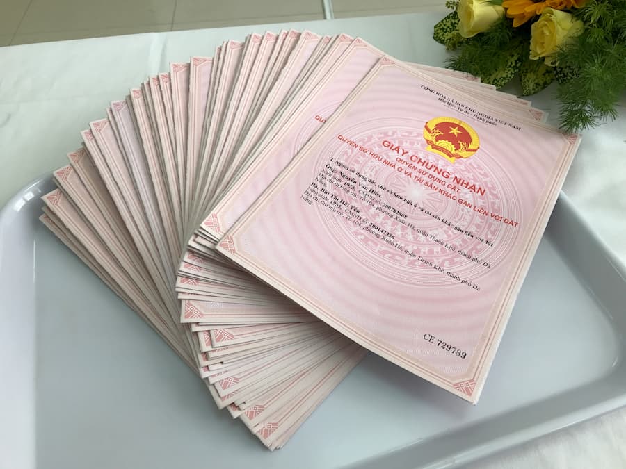 hình ảnh cận cảnh hàng loạt sổ đỏ xếp chồng lên nhau