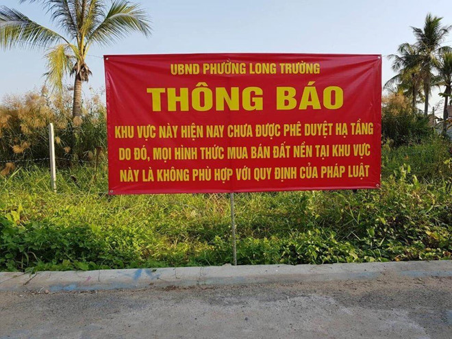 d&ograve;ng chữ tr&ecirc;n biển m&agrave;u đỏ treo tại khu đất trống