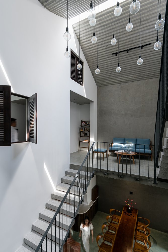 hình ảnh khoảng thông tầng từ phòng ăn lên tầng 2 nhà phố nơi đặt ghế sofa màu xanh dương làm góc thư giãn, đọc sách