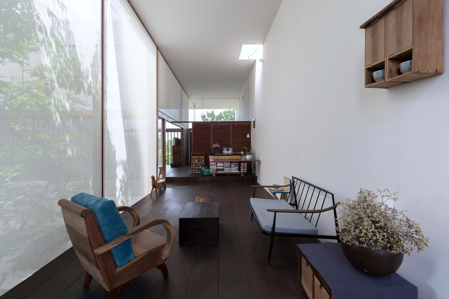 ph&ograve;ng sinh hoạt chung ở tầng tr&ecirc;n với sofa gỗ truyền thống, b&agrave;n tr&agrave;, tường k&iacute;nh trong suốt