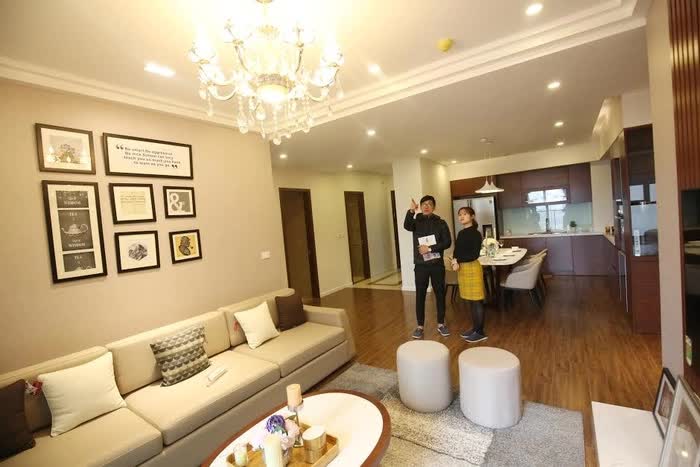 hai người đang đứng bên trong một căn hộ chung cư