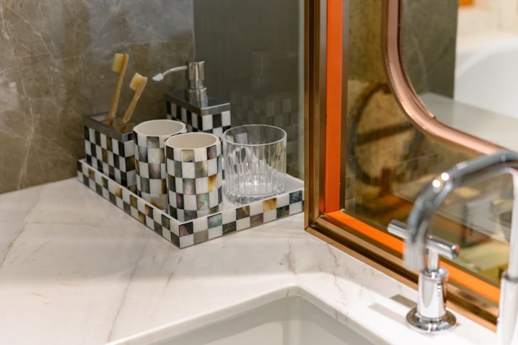 Những vật dụng c&aacute; nh&acirc;n được đặt gọn g&agrave;ng trong khay cạnh bồn rửa ph&ograve;ng tắm.