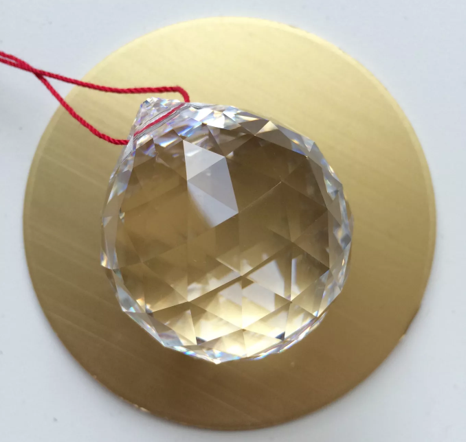 h&igrave;nh ảnh cận cảnh quả cầu pha l&ecirc; trong suốt, nhiều mặt với d&acirc;y treo m&agrave;u đ&ograve;