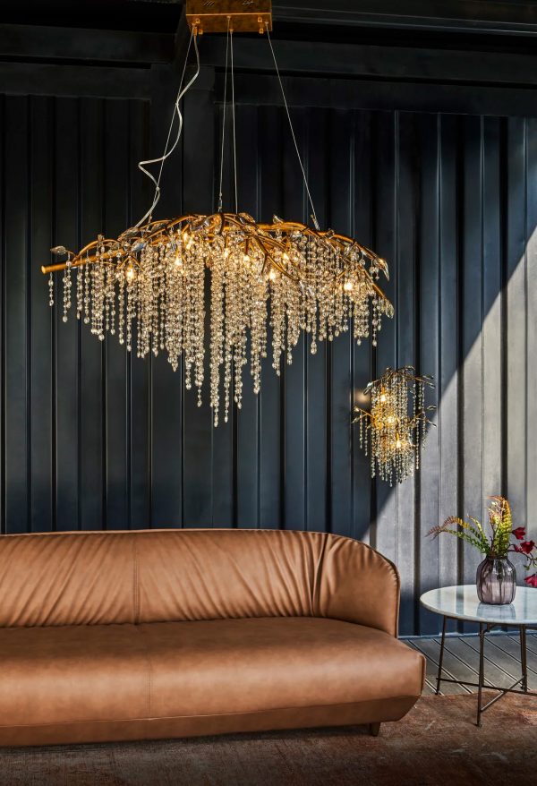 H&igrave;nh ảnh một g&oacute;c ph&ograve;ng kh&aacute;ch với đ&egrave;n ch&ugrave;m pha l&ecirc; v&agrave;ng, sofa m&agrave;u n&acirc;u v&agrave;ng