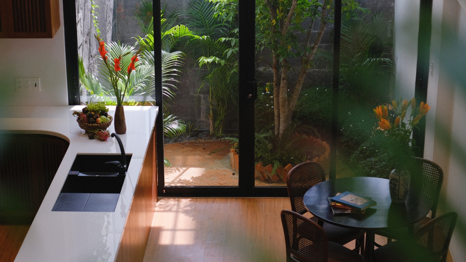 h&igrave;nh ảnh kh&ocirc;ng gian bếp v&agrave; b&agrave;n ăn trong nh&agrave; ống 4 tầng hướng T&acirc;y nh&igrave;n ra s&acirc;n vườn b&ecirc;n ngo&agrave;i