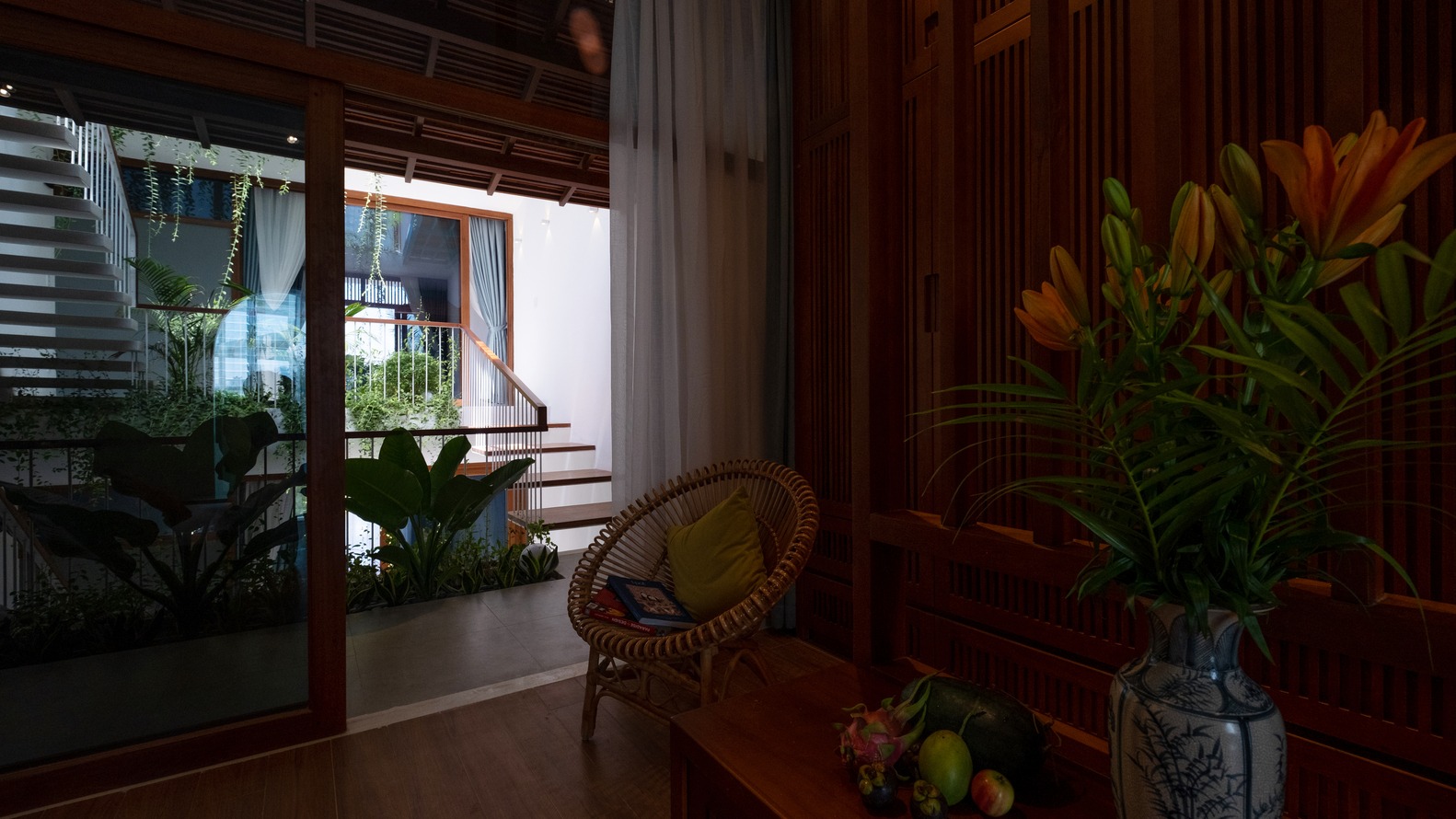 h&igrave;nh ảnh một g&oacute;c ph&ograve;ng kh&aacute;ch nh&igrave;n ra h&agrave;nh lang, khoảng th&ocirc;ng tầng ngập nắng v&agrave; c&acirc;y xanh b&ecirc;n ngo&agrave;i