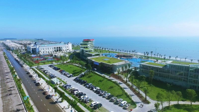 h&igrave;nh ảnh một g&oacute;c Sầm Sơn nh&igrave;n từ tr&ecirc;n cao với nh&agrave; cao tầng, thấp tầng, biển, c&acirc;y xanh, đường quốc lộ