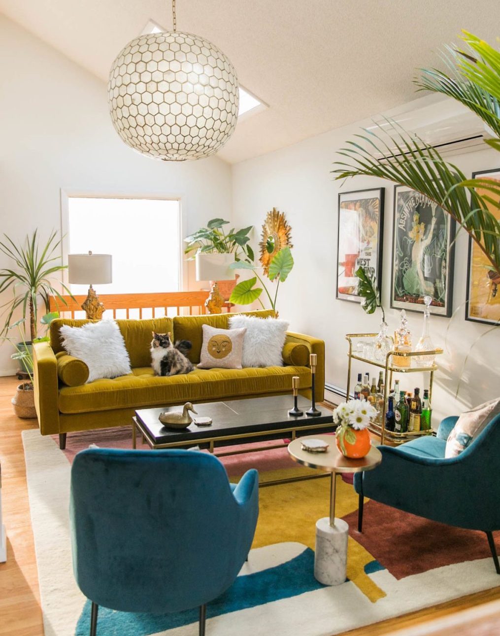 phòng khách với sofa màu vàng mù tạt, ghế tựa xanh mòng két