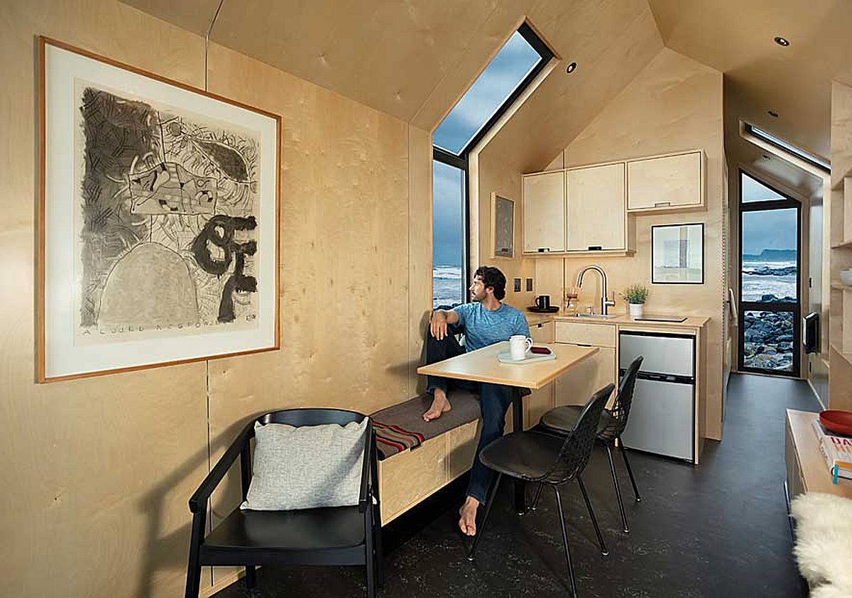 Kh&ocirc;ng gian tiếp kh&aacute;ch v&agrave; nh&agrave; bếp nhỏ b&ecirc;n trong cabin được ốp bằng v&aacute;n &eacute;p.