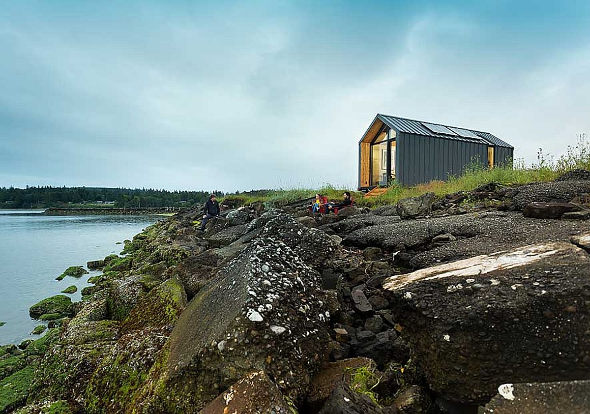 h&igrave;nh ảnh nh&agrave; cabin b&ecirc;n m&eacute;p hồ với đ&aacute; đen lởm chởm
