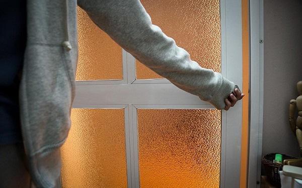 h&igrave;nh ảnh cận cảnh người mặc &aacute;o kho&aacute;c m&agrave;u ghi đang đ&oacute;ng k&iacute;n cửa k&iacute;nh mờ sau khi sử dụng