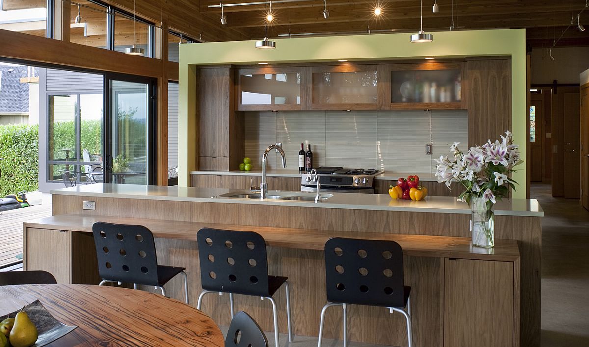 Nh&agrave; bếp hiện đại với đảo bếp bằng gỗ tự nhi&ecirc;n, quầy bar ăn s&aacute;ng tiện dụng c&ugrave;ng một ch&uacute;t m&agrave;u xanh l&aacute; c&acirc;y nhạt bổ sung bảng m&agrave;u sinh động, tr&agrave;n đầy sức sống.