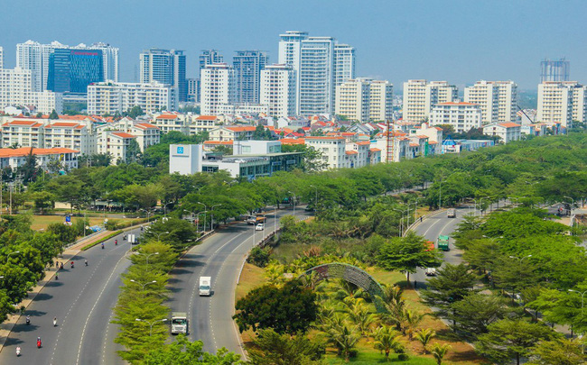 tuyến đường cao tốc có nhiều cây xanh, phía xa có nhiều tòa nhà cao tầng