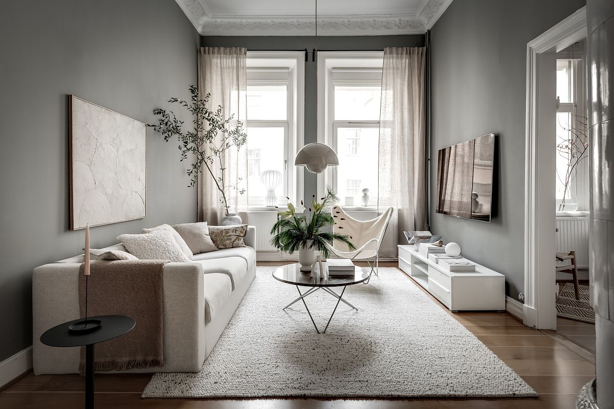 Ph&ograve;ng kh&aacute;ch phong c&aacute;ch Scandinavian nhỏ với những bức tường x&aacute;m v&agrave; một ch&uacute;t xanh l&aacute; c&acirc;y tạo điểm nhấn sinh động.