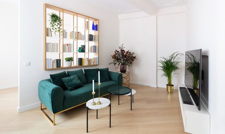 h&igrave;nh ảnh ph&ograve;ng kh&aacute;ch với sofa m&agrave;u xanh ngọc, gi&aacute; s&aacute;ch độc đ&aacute;o
