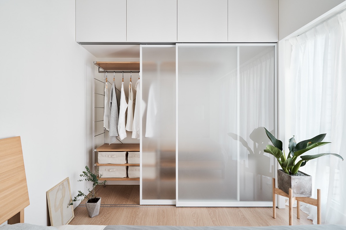 Góc phòng ngủ nổi bật với chậu trồng cây bằng bê tông đặt trên giá gỗ độc đáo.