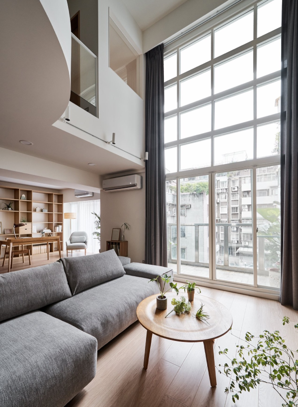 hình ảnh phòng khách với ghế sofa xám, bàn cà phê tròn bằng gỗ, phía trên đặt chậu cảnh mini