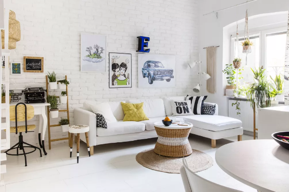 Phòng khách nhỏ tối giản sắc trắng chủ đạo nhưng vẫn rất sinh động, tràn đầy sức sống nhờ những chậu cảnh xanh mát đặt trên giá kệ, treo và bên bệ cửa sổ.